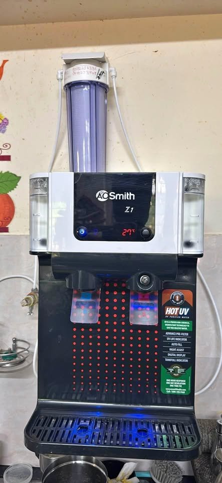AO Smith Z1 UV water purifier front close-up view with glowing blue night dispensing light and digital temperature display showing 27°C