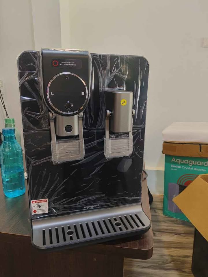 Aquaguard Blaze Insta water purifier front close-up view showing child lock safety featureinstalled on right side hot water dispenser tap, and removable drip tray.