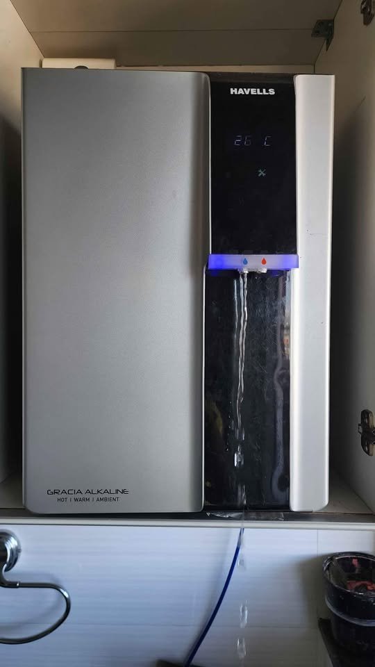 Havells Gracia Alkaline water purifier front view dispensing normal water from tap with blue LED indicator